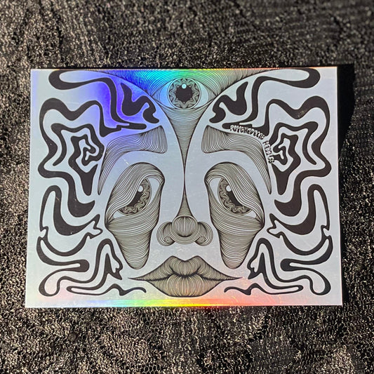 Holographic sticker with abstract face design on a glossy surface