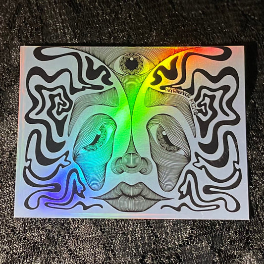 Holographic sticker with abstract face design on a glossy surface